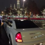 Schicke Limousine, die durch eine beleuchtete Wiener Straße fährt